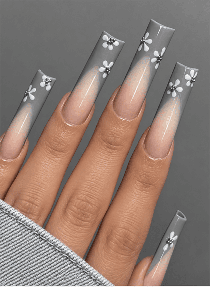 Gray ombré coffin nails with nude bases, white floral nail art and silver rhinestone accents