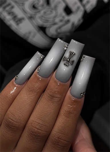 Gray ombré coffin nails with silver cross charm, rhinestone accents and a glossy finish