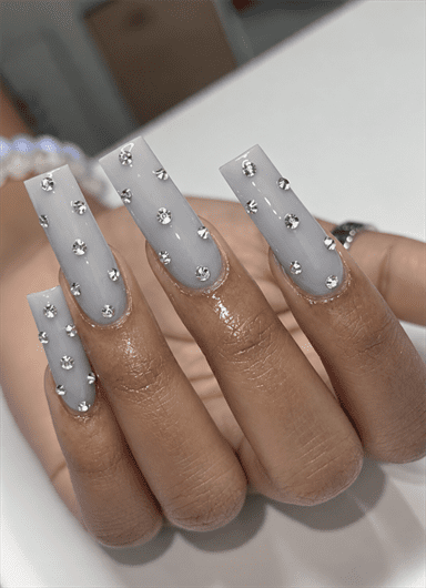 Gray coffin nails with scattered silver rhinestone embellishments and a glossy finish