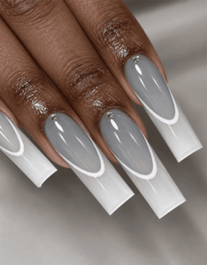 Gray and white French tip coffin nails with curved double-line accents and a glossy finish
