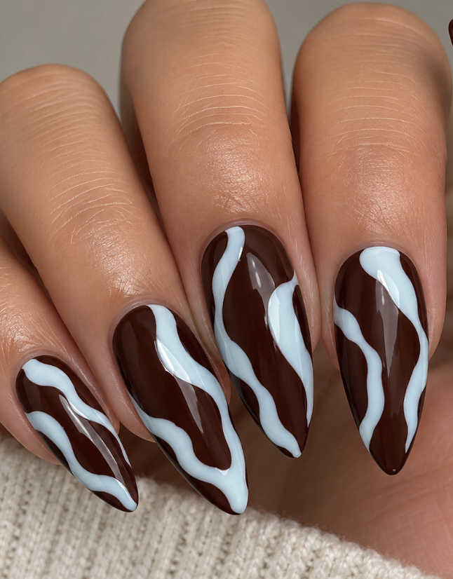Chocolate brown almond nails with light blue abstract wavy lines and a glossy finish