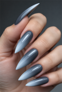 Smoky blue-gray ombré stiletto nails with light blue pointed tips and a glossy finish