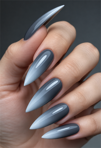 Smoky blue-gray ombré stiletto nails with light blue pointed tips and a glossy finish