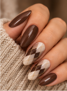 Long almond nails with chocolate brown polish, cream argyle accents, gold lines and glossy finish.