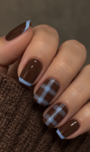 Short square chocolate brown nails with baby blue French tips and glossy blue plaid accents.