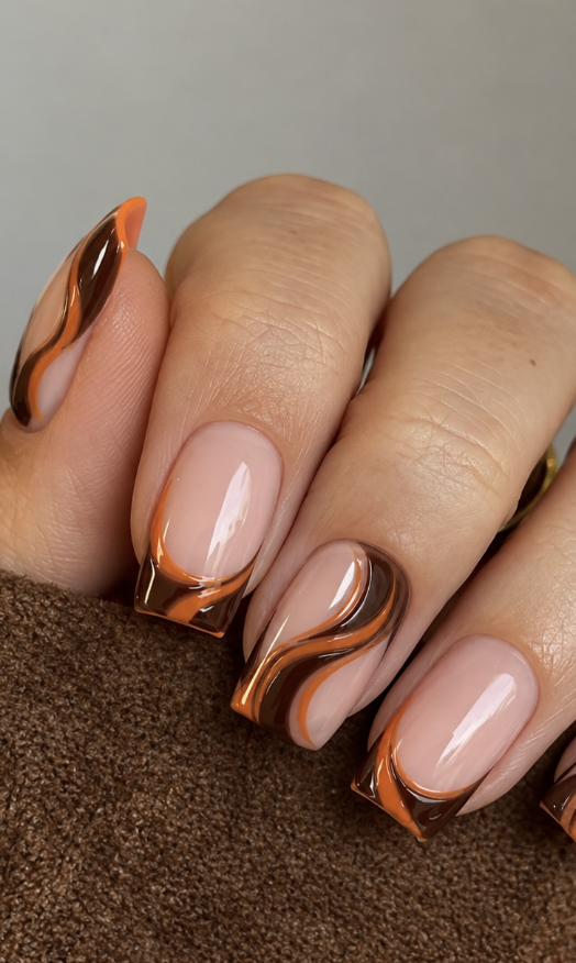Medium-long square nails with glossy nude bases, chocolate brown swirls, burnt orange waves and French tips.