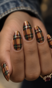 Long almond nails with mustard yellow tartan plaid, forest green stripes, burgundy lines and gold accents.