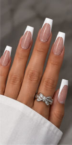 Long square nails with sheer pink glitter bases, crisp white French tips and glossy finish.
